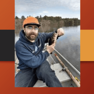 Man in boat holding caught fish.
