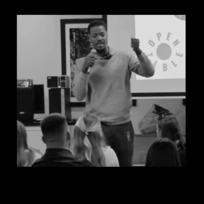 Man giving presentation, microphone in hand.