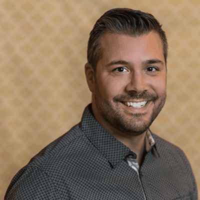 Smiling man in a patterned shirt.