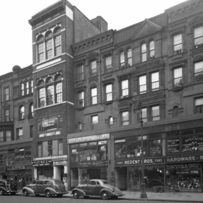 Black and white photo of city street shops.