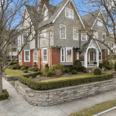 Large gray house with stone wall.