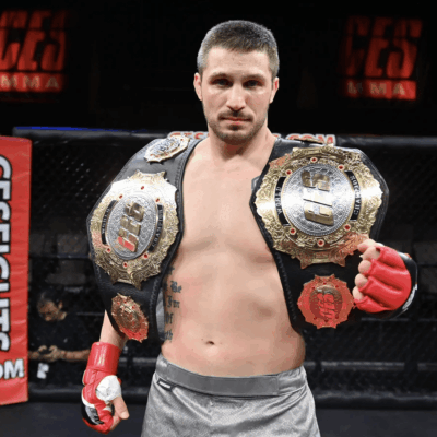 MMA fighter holding championship belt.