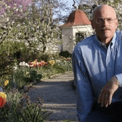 Man in garden with spring flowers.