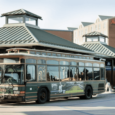 Green trolley at hotel transportation stop.