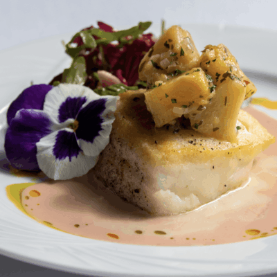 Pan-seared fish with fruit and sauce.