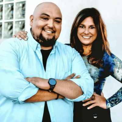 Man and woman smiling, arms crossed.