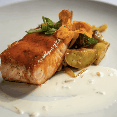 Glazed salmon with vegetables and sauce.