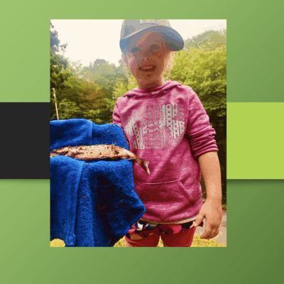 Smiling girl holding a caught fish.