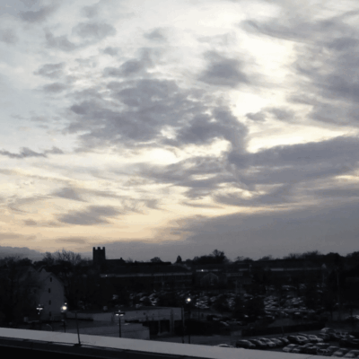 Cloudy sunset over town parking lot.
