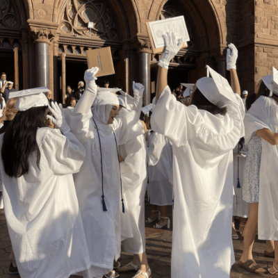 Graduating class celebrating outside church.