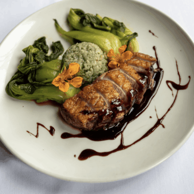 Pan-seared duck breast with green rice and bok choy.