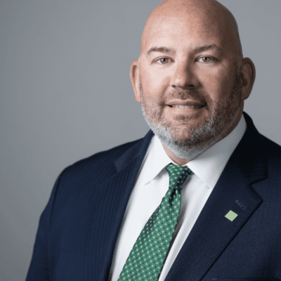 Here's an alt tag for the image: Smiling businessman in suit and tie.