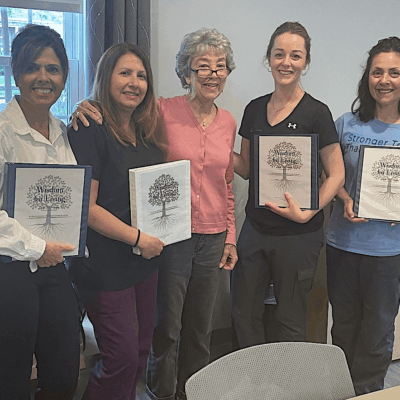 Five women holding "Wisdom for Living" books.