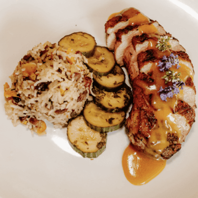 Pan-seared duck breast with rice and zucchini.