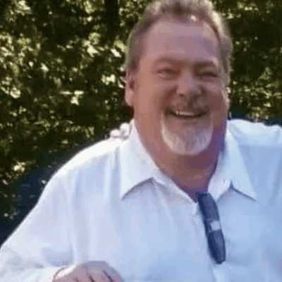 Happy man in a white shirt outdoors.