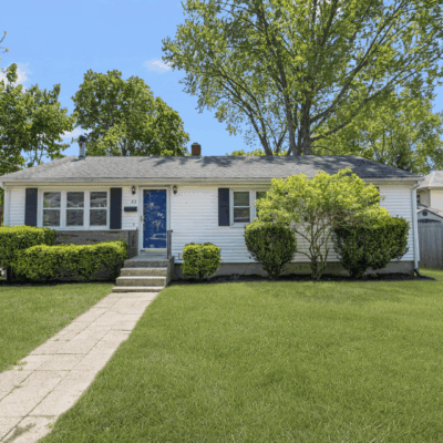 White Ranch house with green lawn.