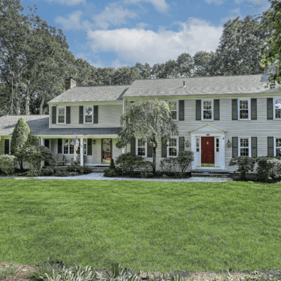Colonial-style house with green lawn.