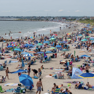 Crowded beach with colorful umbrellas.