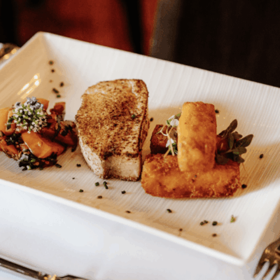 Pan-seared fish with fried potatoes and garnish.