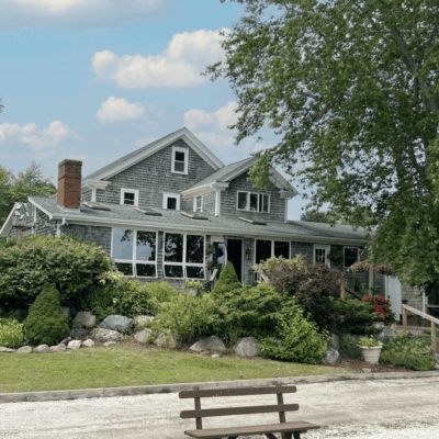 Gray shingled house with porch and landscaping