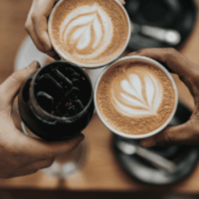 Three hands clinking coffee cups.