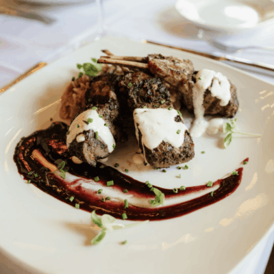 Grilled lamb chops with sauce and herbs.