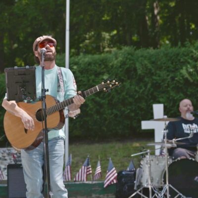 Man singing and playing acoustic guitar.