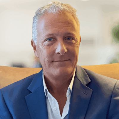 Here's an alt tag for the image: Man in blue suit, headshot.