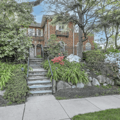 Brick house with stone steps and flowers.