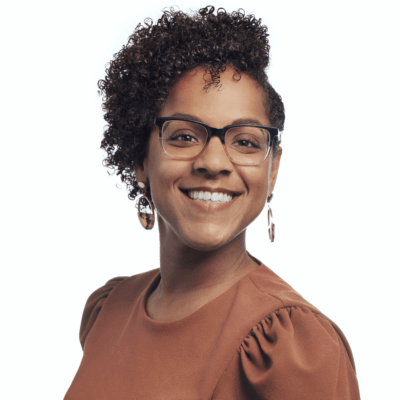 Smiling woman with glasses and curly hair.
