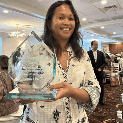 Woman holding award for dedication.