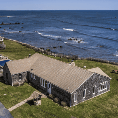 Oceanfront cottage with lawn and pool.