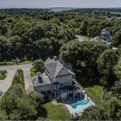 Aerial view of waterfront house with pool.