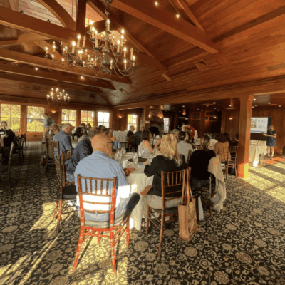 Business meeting in a wood-paneled room.