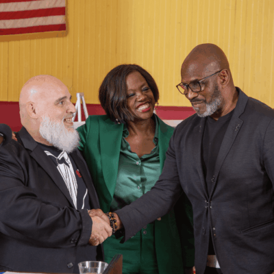 A man and two women shaking hands.
