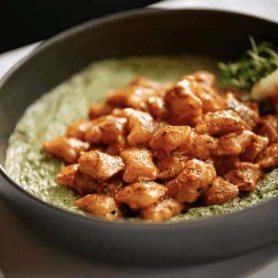 A bowl of food with meat and vegetables.