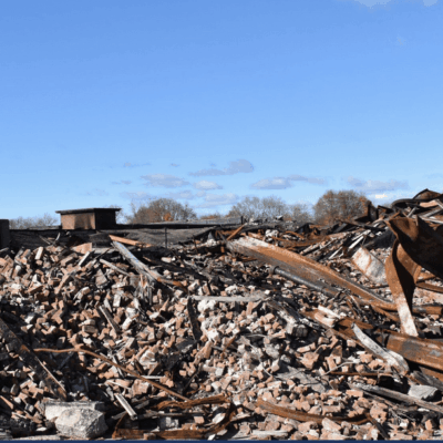 A pile of rubble with a building in the background.
