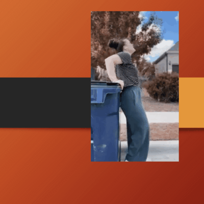 A woman leaning on the side of a trash can.