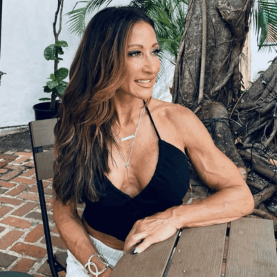 A woman sitting on top of a wooden bench.