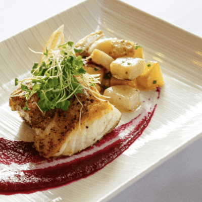 A white plate topped with fish and vegetables.