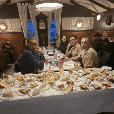 A group of people sitting at a table with plates and sandwiches.
