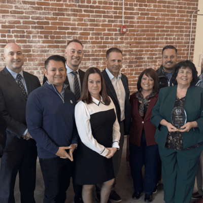 A group of people standing in front of a brick wall.