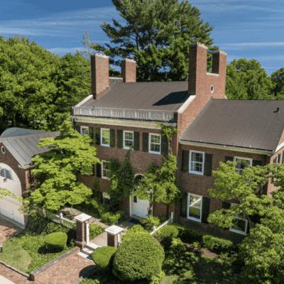 A large brick house with trees in the background.