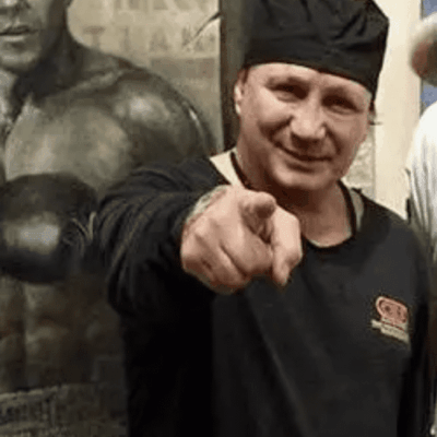 A man in black shirt pointing at the camera.