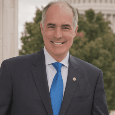 A man in suit and tie standing outside.