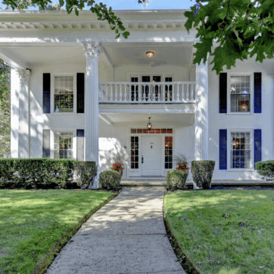 A white house with blue shutters and a porch.