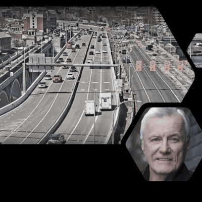 A man is standing in front of an image of the freeway.