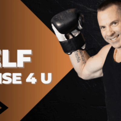 A man with boxing gloves is smiling for the camera.