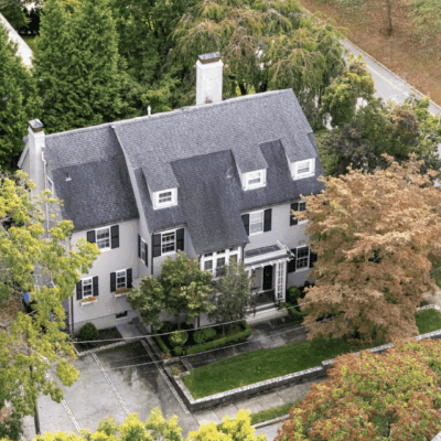 A large white house with trees in the background