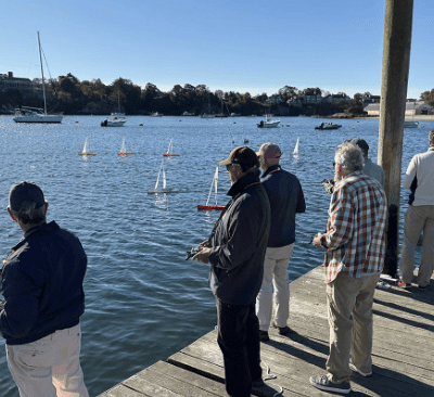 A group of people standing on the pier near water.